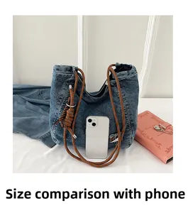 Detailed comparison showing large denim tote bag size next to a smartphone