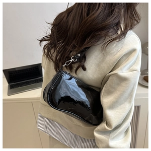 Model view of black patent leather shoulder bag with sleek silver metal hardware