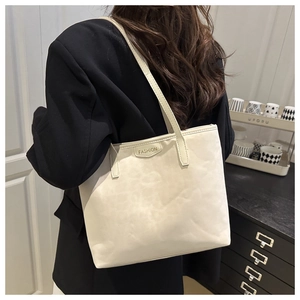 Detail of minimalist tote bag with FASHION lettering and slim shoulder strap