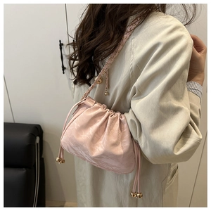 Détail du sac seau rose à cordon avec perles dorées et bandoulière chaîne
