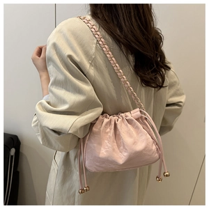 Détail du sac seau rose clair motif marbre avec bandoulière chaîne dorée sur mannequin
