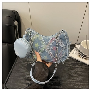 Dettaglio borsa hobo in denim azzurro con stampe di stelle, frange e catena argento