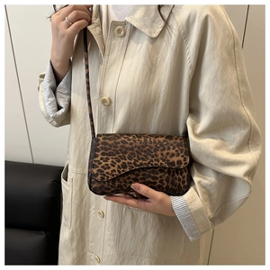 Dettaglio della borsa a tracolla leopardata indossata con un trench beige chic