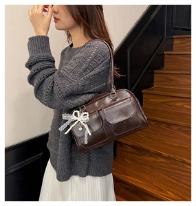Gros plan du sac Boston marron rétro avec charme perle noeud et poches de rangement