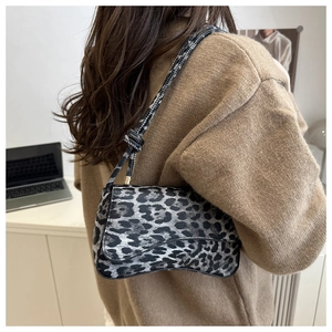Dettaglio della borsa a sella leopardata a spalla con un design curvo particolare