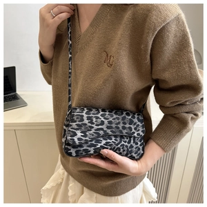 Dettaglio di una borsa a tracolla vintage leopardata con cinturino in pelle nera