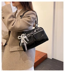 Mannequin portant un sac bowling noir brillant avec breloques perles et nœud dentelle
