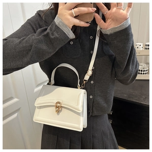 White structured crossbody bag featuring a signature gold double-ring clasp closure