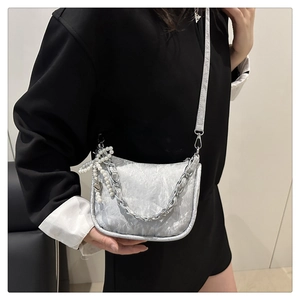 Détail du sac argenté plissé avec grosse chaîne et breloques cœur en perles