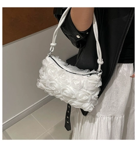 Detail of white 3D floral shoulder bag with dense rose petals and a knotted strap