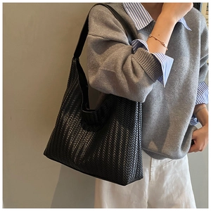 Detail of black woven tote bag showing premium texture and moon-shaped shoulder design