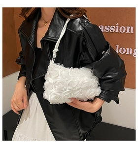 Gros plan sur la texture florale 3D d'un sac de soirée blanc avec roses en satin