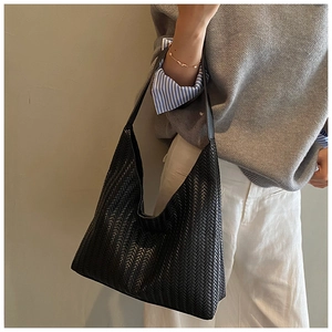 Close-up of black leather hobo bag featuring premium V-shaped woven texture detail