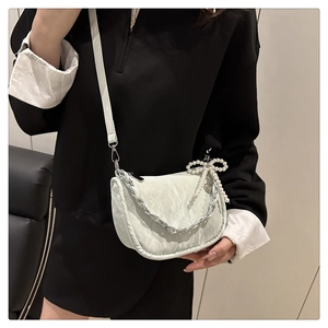 Détail du sac bandoulière blanc moiré avec chaîne argentée et nœud en perles