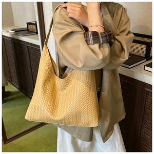 Detail view of beige woven hobo bag showing intricate V-pattern texture and minimalism