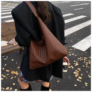 Close-up of brown woven hobo bag showing detailed V-shaped leather texture and strap