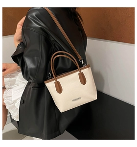 Detail of contrast stitch tote bag featuring silver FASHION logo and litchi grain texture