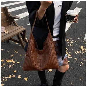 Detail of dark brown woven leather tote with large capacity for autumn commuting