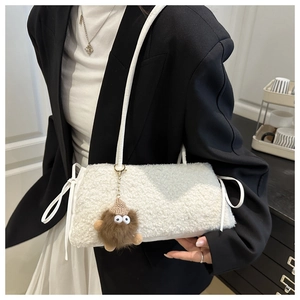 Close-up of fluffy white faux fur tote bag featuring a cute brown monster charm