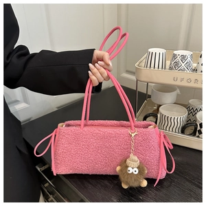 Detail of pink faux fur tote bag with cute plush pendant and slim handles