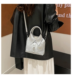 Close-up of silver leather bucket bag with creative shirt collar design and metallic texture