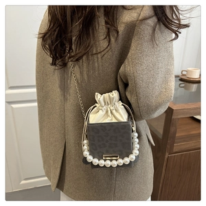 Detail der grauen Mini-Tasche mit Leopardenmuster, Perlengriff und Goldkette