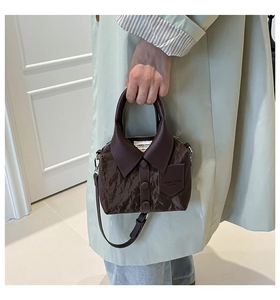 Close-up of dark brown leather handbag with creative shirt collar and button design