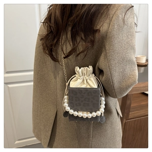 Detail of grey leopard print bag with pearl handle and golden chain strap for women