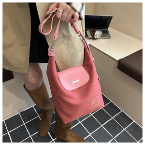 Pink canvas tote bag with bone buckle detail and cute puppy print worn by model