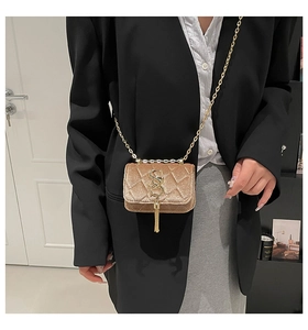 Détail du sac bandoulière en velours avec broderie matelassée et chaîne dorée