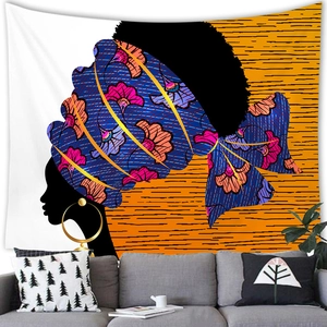 Detail of African woman tapestry hanging above a gray sofa in a modern artistic living room