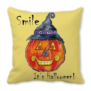 Detail of Halloween pumpkin smiling with wizard hat on peach skin fabric cushion