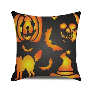Detail of Halloween throw pillow with pumpkin, skull, and bat motifs on black fabric