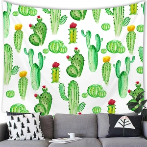Sunset watercolor cactus tapestry hanging on a white wall above a grey fabric sofa