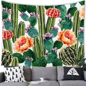 Detailed desert cactus wall tapestry hanging over a grey sofa in a cozy home setting