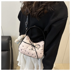 Detail van de roze gewatteerde schoudertas met zwarte strikken en pluche konijnenhanger