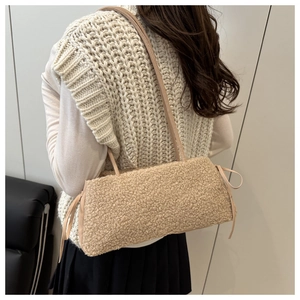 Detail of plush beige tote bag with soft faux shearling texture and side drawstring bows