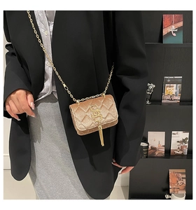 Détail du mini sac matelassé en velours champagne avec pompon doré et chaîne