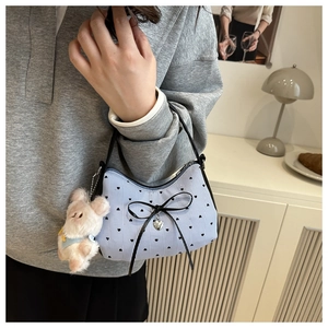 Détail du sac hobo à rayures bleues avec imprimés cœurs et décoration de nœud noir