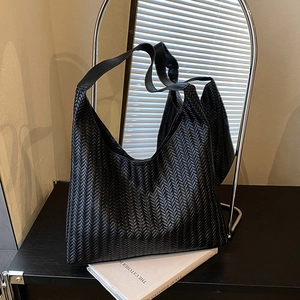 Minimalist black woven hobo shoulder bag with herringbone texture and wide strap