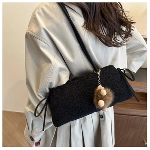 Detail of black faux shearling tote bag with side bows and cute brown bear charm