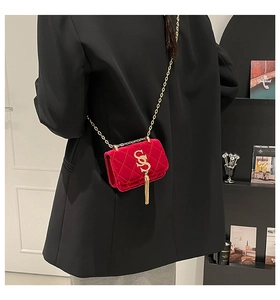 Sac bandoulière chic en velours rouge matelassé avec pompon doré et chaîne élégante