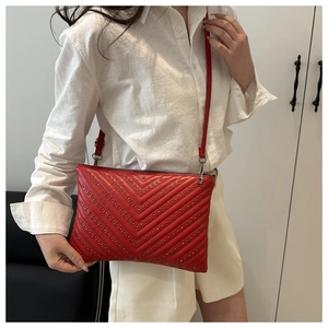 Borsa a tracolla trapuntata rossa con borchie indossata per uno stile casual