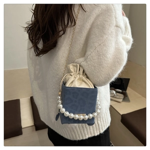 Detail der blauen Eimertasche mit Leopardenmuster, Perlenhenkel und goldener Kette