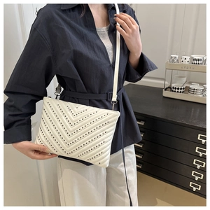 Detail of white envelope crossbody bag with V-quilted stitching and silver rivets
