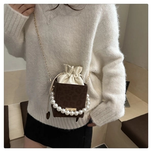 Detail of leopard print bucket bag with pearl handle and inner drawstring pouch