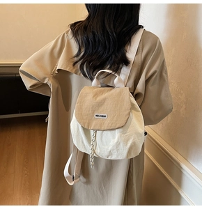 Detail of two-tone nylon backpack with You Ji Bear logo and checkered drawstring cord