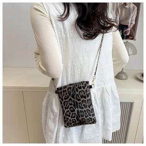 Close-up of leopard print small square bag with elegant gold chain strap detail