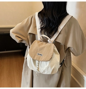 Detailed view of the woven drawstring closure and brand plaque on a nylon backpack