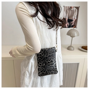 Model view of leopard print crossbody bag featuring an elegant gold chain shoulder strap